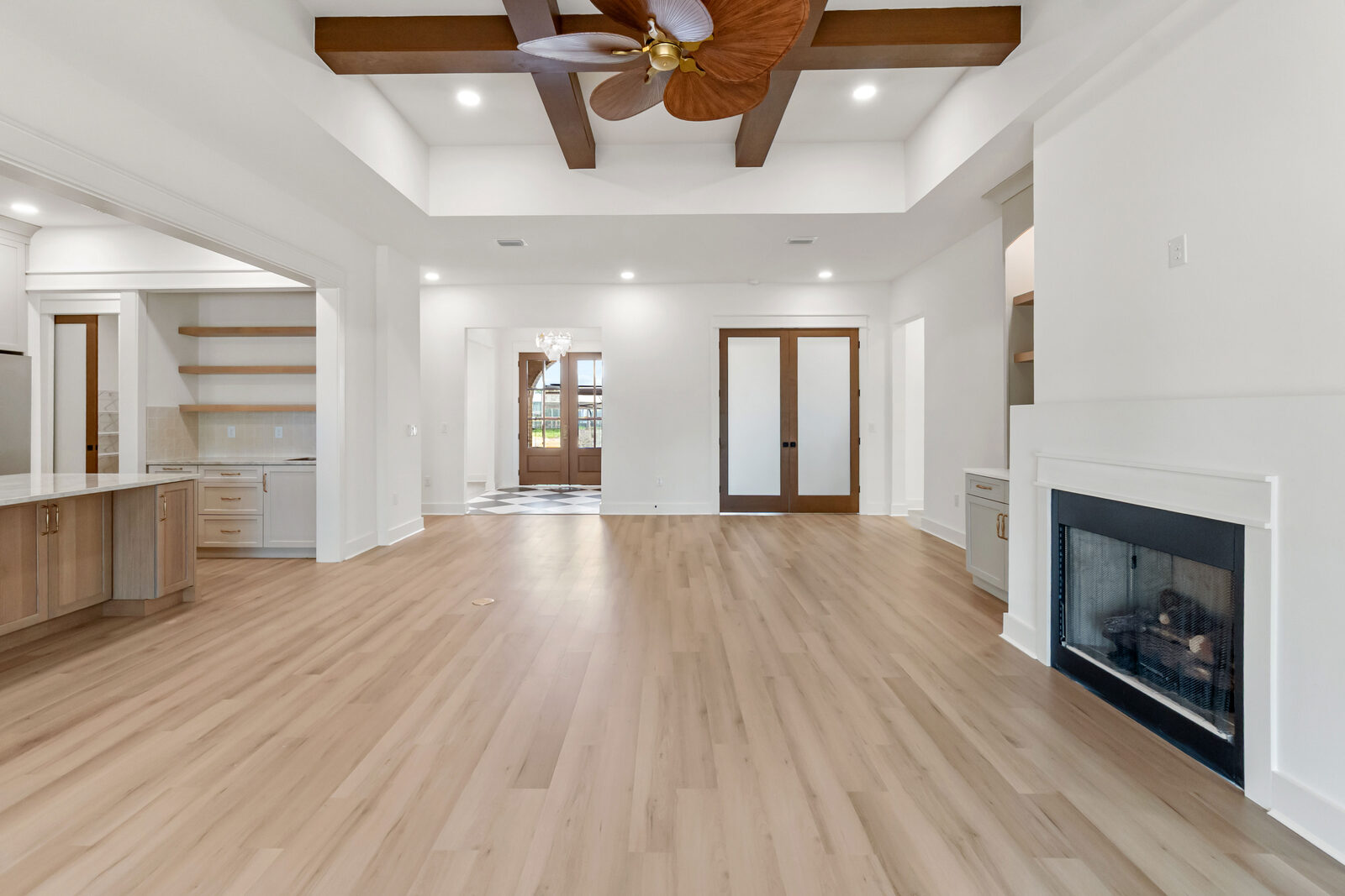 Great room with coffered wood beam ceiling and fireplace in an AJAC Group custom home