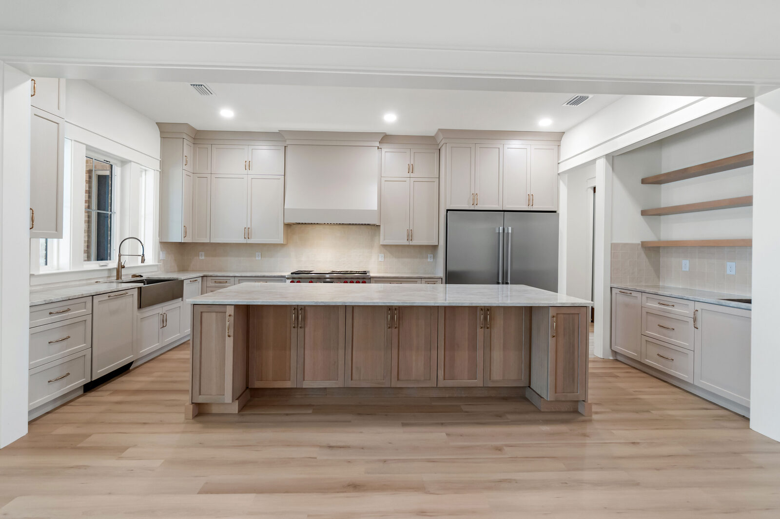 Custom kitchen with large quartzite island and Wolf range in an AJAC Group home